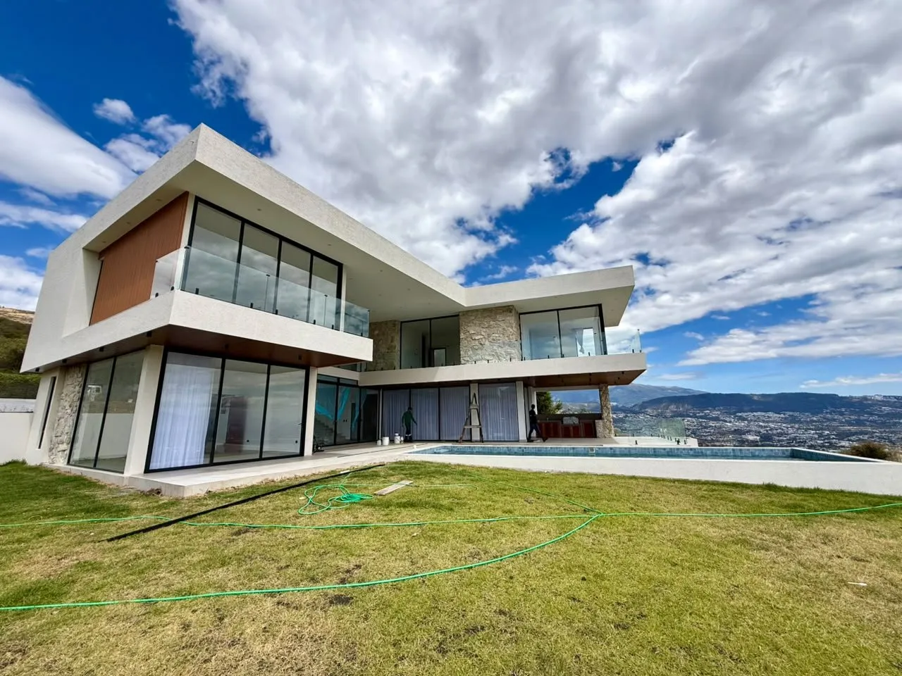 Vivienda contemporánea de volúmenes blancos en voladizo con el jardín terminado